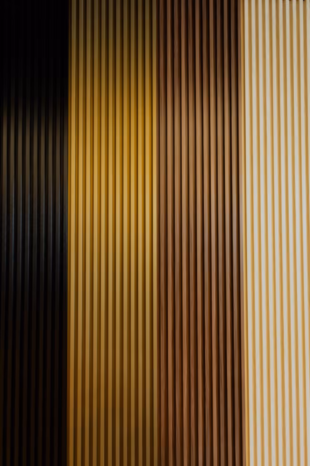 Four slat wall panels side by side in black, golden oak, brown and light finishes