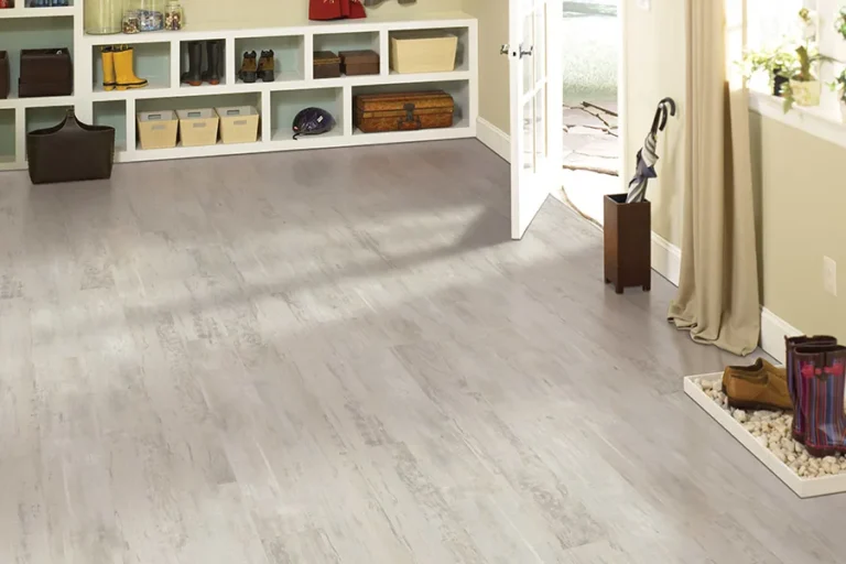 Best Flooring for Flood-Prone Areas: Straight Answers to Real Questions Light gray vinyl plank floor in a home entry with rain boots, an umbrella stand and open storage cubbies