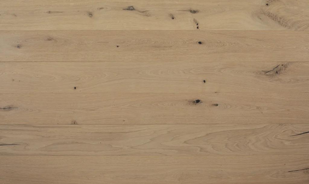 Prefinished vs Unfinished Hardwood: Same Wood, Different Finish Day Prefinished European oak planks in Aged Wide Floors Milan, a pale matte finish with dark knots and visible board edges