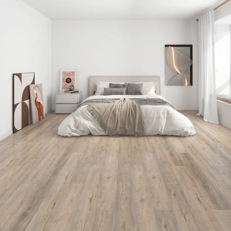 Bedroom with light taupe wood-look Belocore SPC vinyl plank flooring under a low upholstered bed (manufacturer room scene)